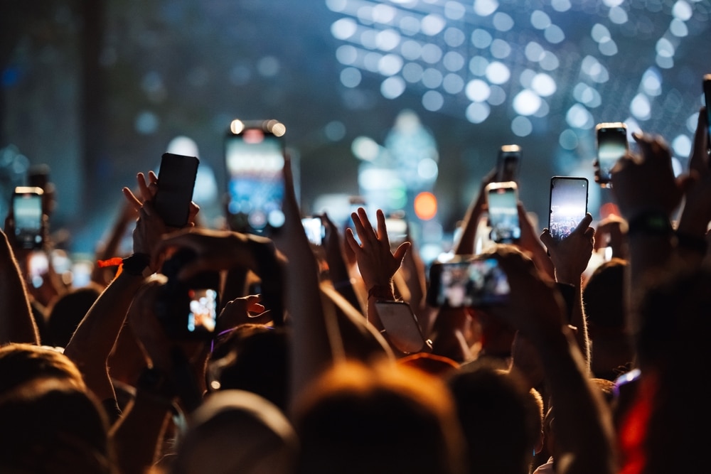 Concert Live : Public avec Smartphones devant la Scène Foule lors d'un concert levant des smartphones pour filmer le spectacle sous les lumières de la scène.