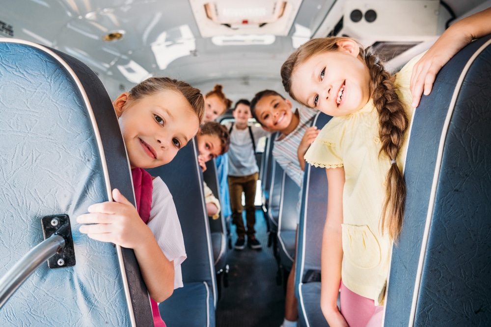 Group,Of,Cute,Schoolchildren,Riding,On,School,Bus,And,Looking